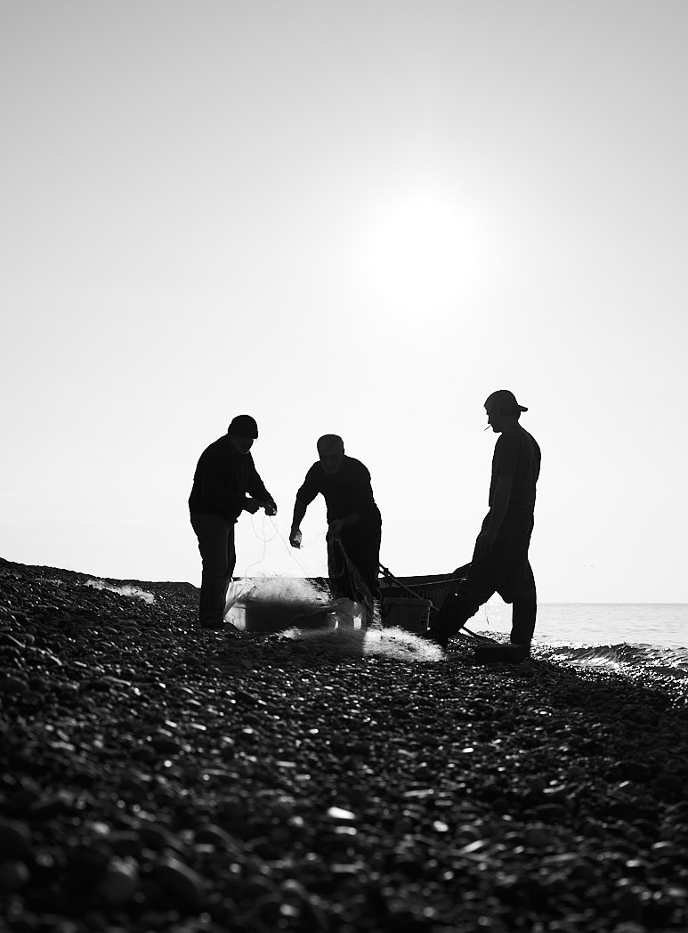 Fishermen at the seashore in black and white