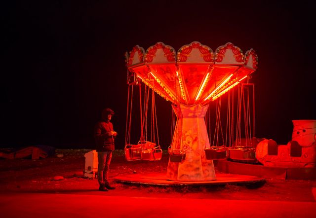 a man near a red light carousel