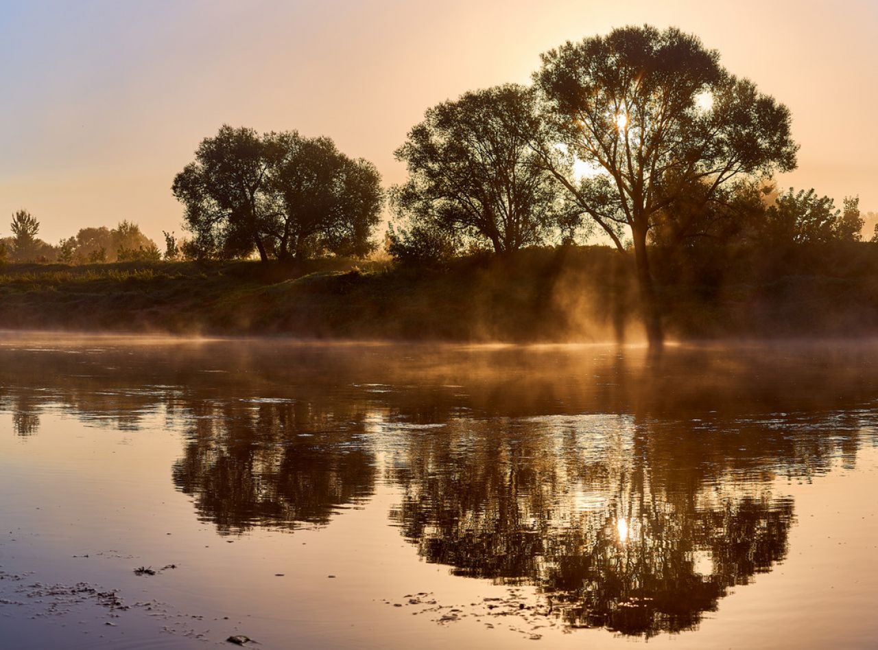 river at sunrise with sun rays