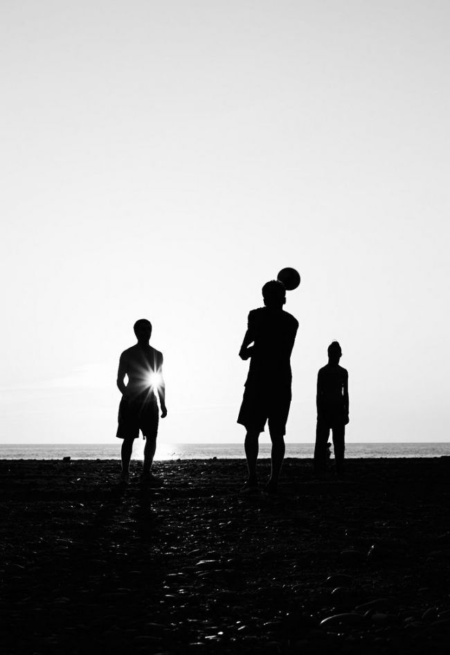 children play at the beach in black and white