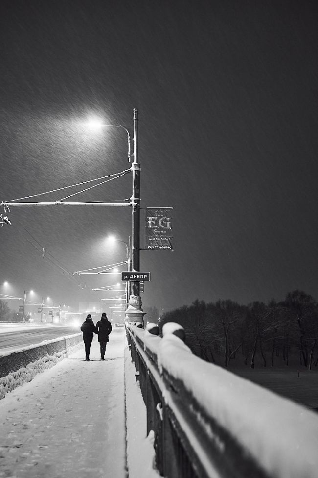 a couple walks along the bridge in winter